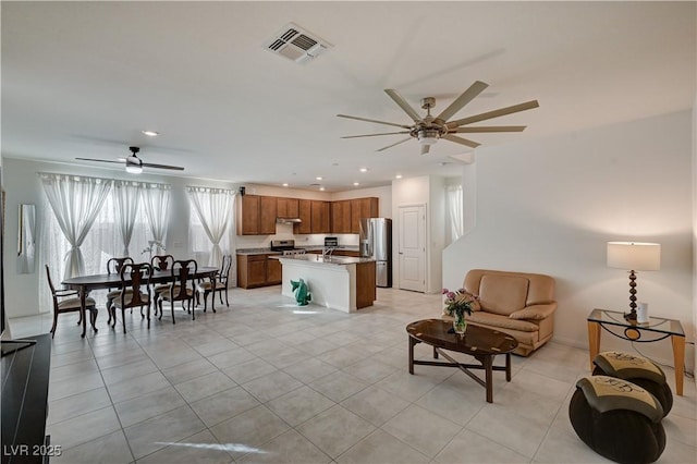 living room featuring ceiling fan, sink, and light tile patterned floors