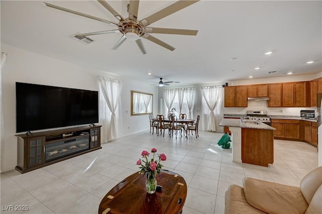 living room with light tile patterned floors, sink, and ceiling fan