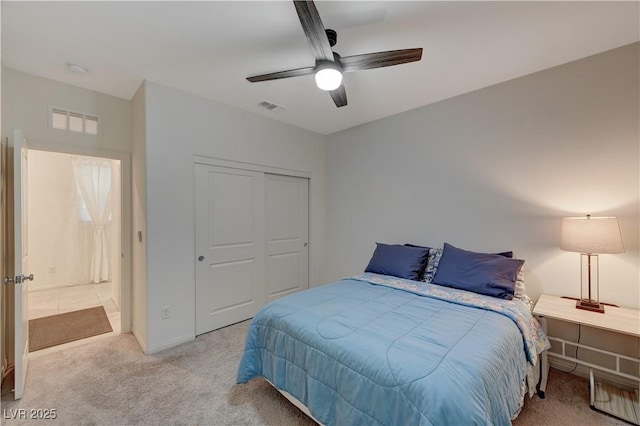 carpeted bedroom with ceiling fan and a closet