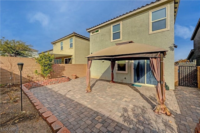 back of house featuring a gazebo and a patio