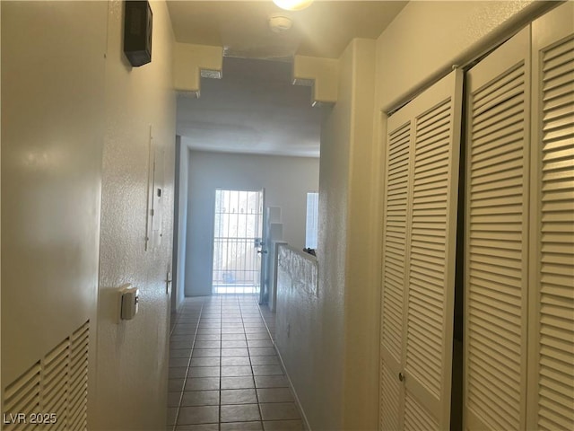 hallway featuring dark tile patterned floors