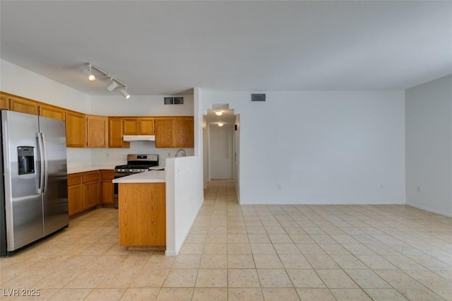 kitchen with stainless steel appliances, rail lighting, and light tile patterned floors