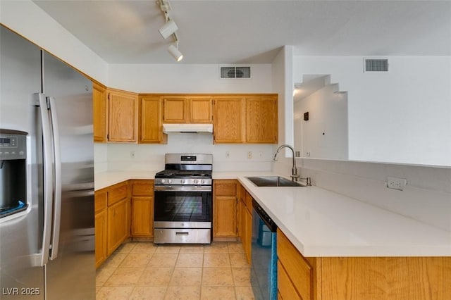 kitchen featuring light tile patterned flooring, track lighting, appliances with stainless steel finishes, and sink