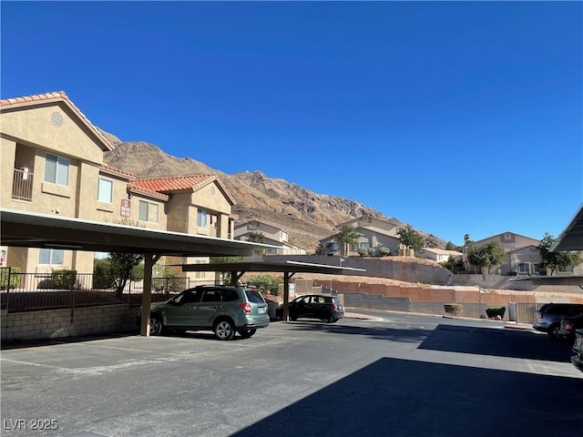 view of car parking with a mountain view and a carport