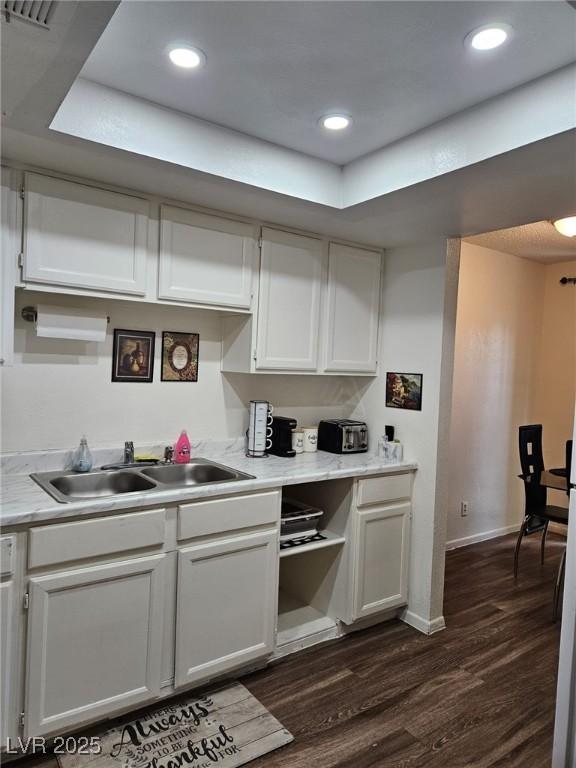 kitchen featuring white cabinetry, sink, and dark wood-type flooring