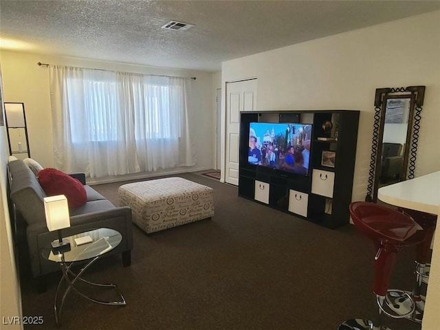 carpeted living room featuring a textured ceiling