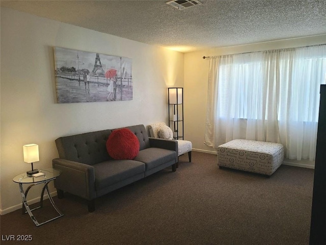 living room featuring dark carpet and a textured ceiling