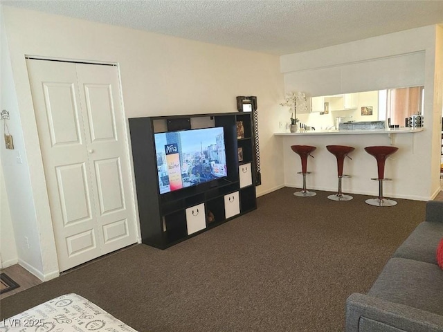 living room with dark carpet and a textured ceiling