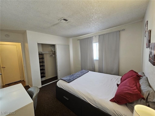 carpeted bedroom with a closet and a textured ceiling