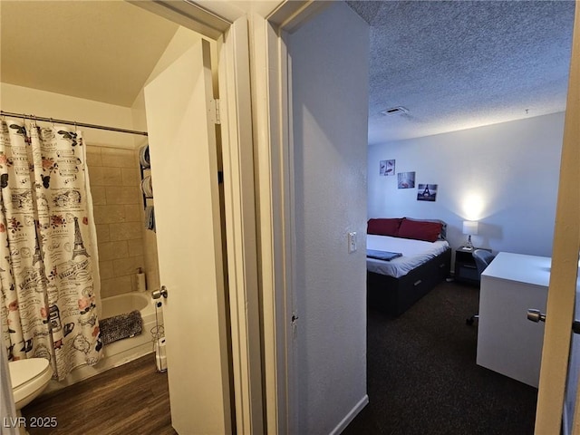 bedroom with dark wood-type flooring and a textured ceiling