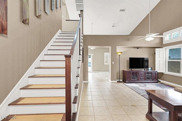 stairway with tile patterned flooring, high vaulted ceiling, and ceiling fan