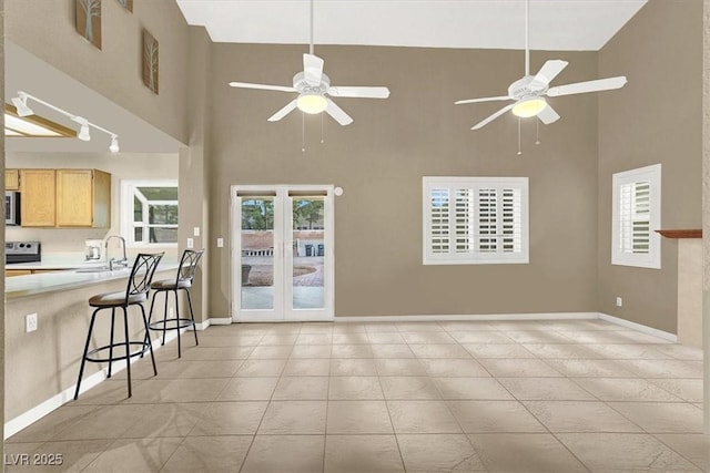 tiled living room featuring sink, a wealth of natural light, and ceiling fan