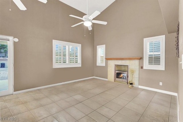 unfurnished living room featuring a tile fireplace, high vaulted ceiling, light tile patterned floors, and ceiling fan