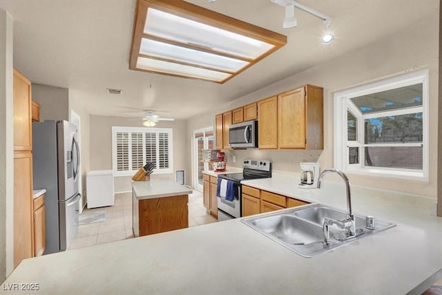 kitchen with appliances with stainless steel finishes, sink, and kitchen peninsula