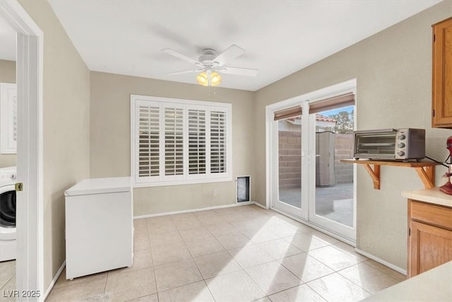 dining area featuring ceiling fan, washer / dryer, and light tile patterned floors