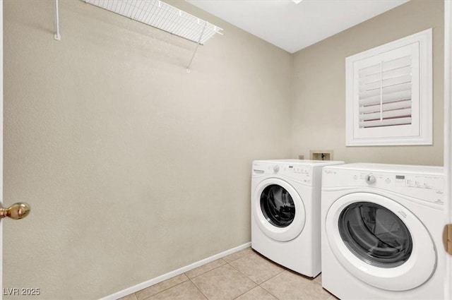 laundry area with washing machine and dryer and light tile patterned floors