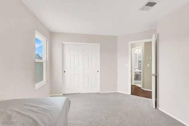 unfurnished bedroom with a closet and light carpet