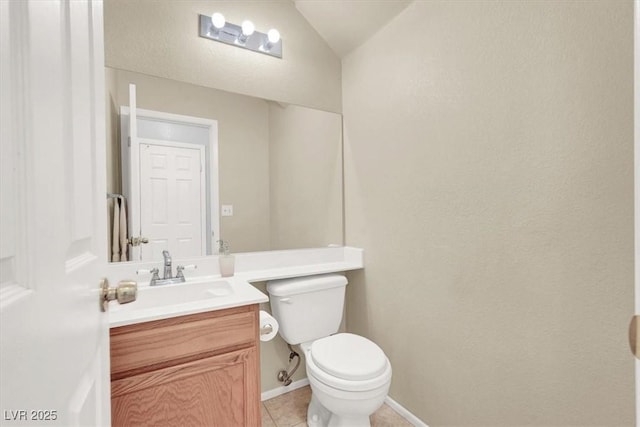 bathroom featuring tile patterned floors, vanity, toilet, and vaulted ceiling