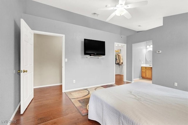 bedroom featuring wood-type flooring, a walk in closet, ceiling fan, and a closet