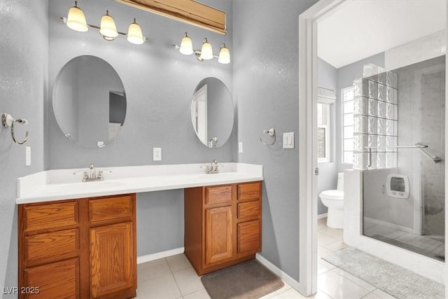 bathroom with vanity, toilet, tile patterned flooring, and a tile shower