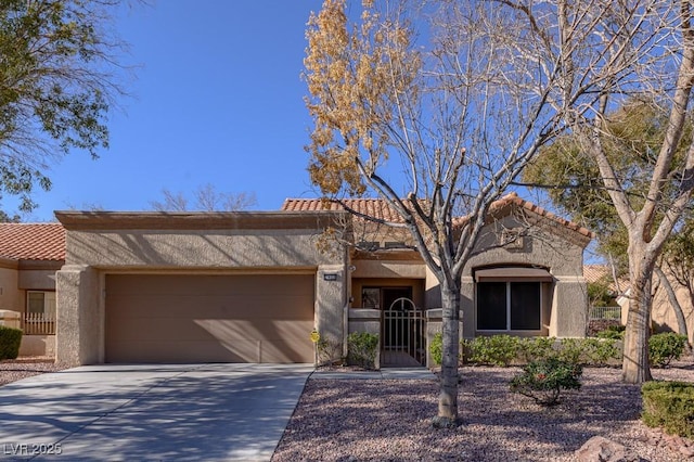 view of front facade with a garage, concrete driveway, a tile roof, and stucco siding