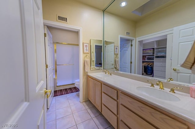 full bathroom with a stall shower, tile patterned flooring, visible vents, and a sink