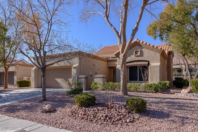 view of front of property featuring a garage, a tiled roof, driveway, and stucco siding