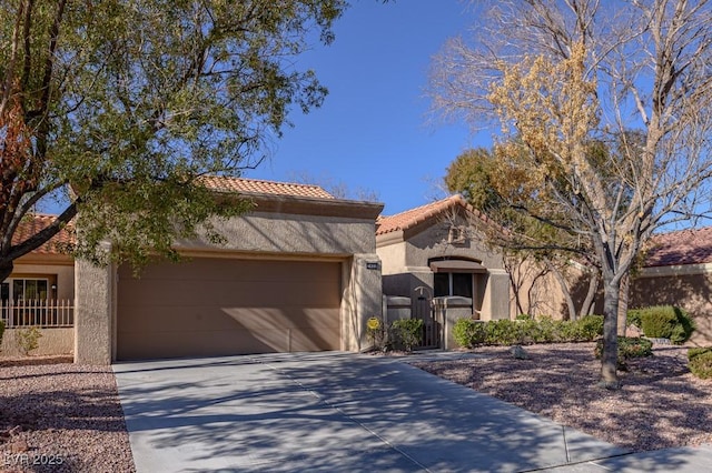 mediterranean / spanish-style home featuring a garage, a tiled roof, concrete driveway, a gate, and stucco siding