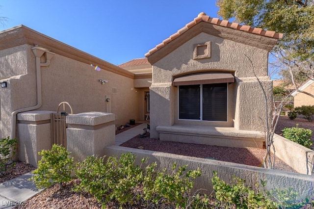 view of front of property featuring a tiled roof and stucco siding