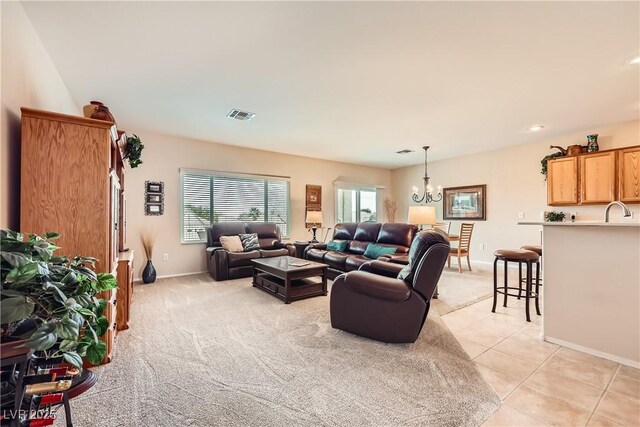 living room with sink, light tile patterned floors, and a chandelier