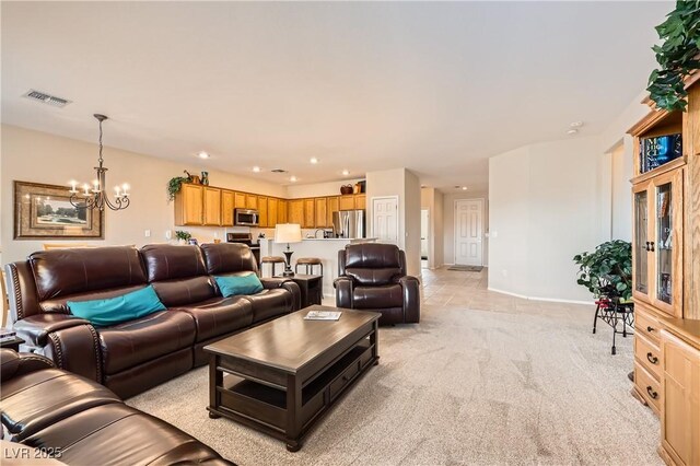 carpeted living room with an inviting chandelier