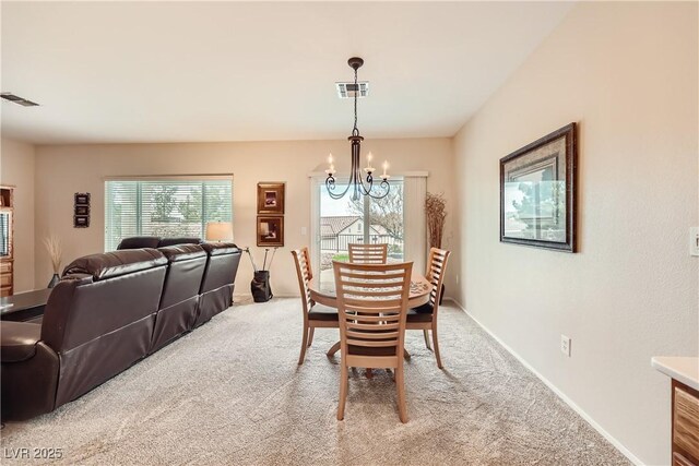 carpeted dining area featuring a notable chandelier