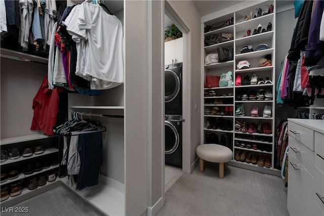 spacious closet featuring stacked washer and clothes dryer and light carpet