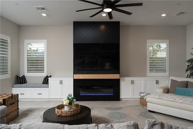 living room featuring a fireplace and ceiling fan