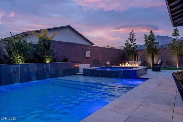 pool at dusk with a patio area and an outdoor fire pit