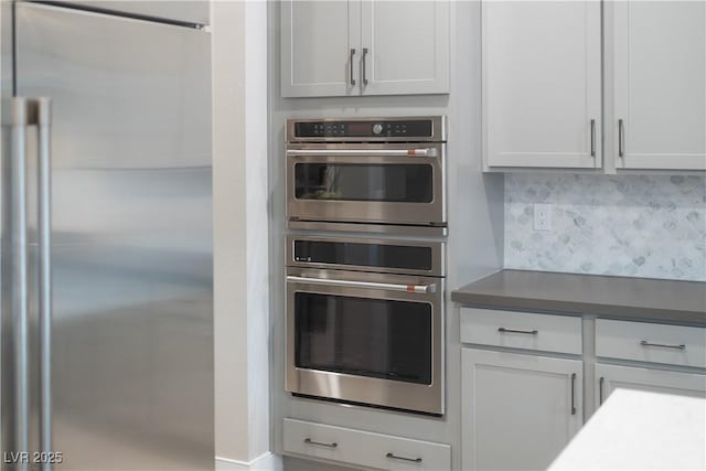 kitchen with white cabinets, appliances with stainless steel finishes, and backsplash