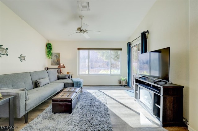 living room with hardwood / wood-style floors, vaulted ceiling, and ceiling fan