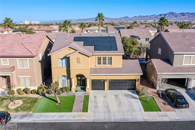 view of front of home featuring a garage, a mountain view, and solar panels