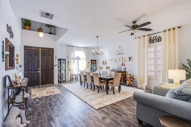 dining space featuring ceiling fan with notable chandelier and dark hardwood / wood-style flooring