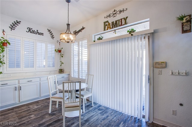 dining room with a notable chandelier and dark hardwood / wood-style flooring