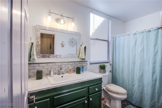 bathroom featuring tasteful backsplash, vanity, and toilet