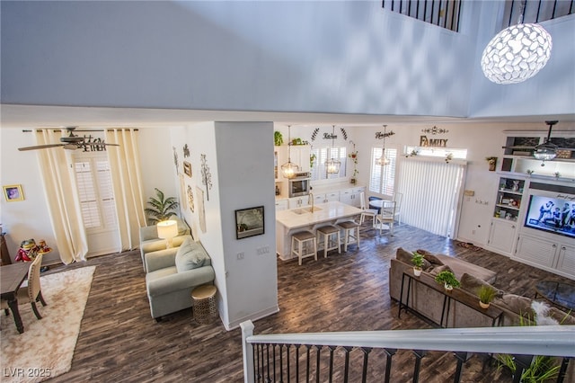 living room featuring dark hardwood / wood-style flooring, sink, and a high ceiling