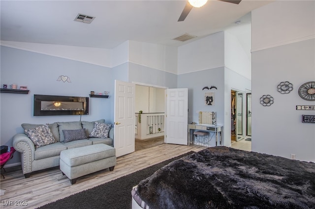 bedroom with light hardwood / wood-style flooring, high vaulted ceiling, and ceiling fan