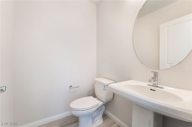 bathroom featuring hardwood / wood-style flooring and toilet