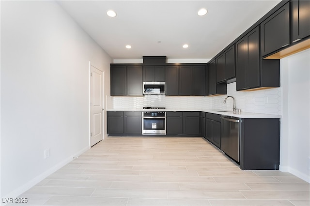 kitchen featuring stainless steel appliances, light hardwood / wood-style floors, sink, and decorative backsplash