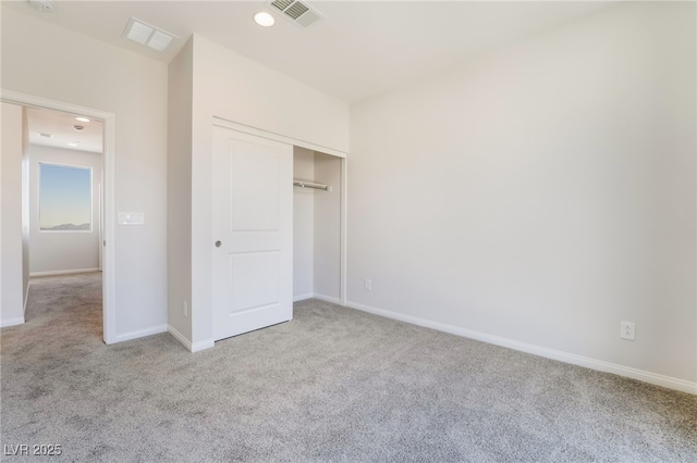 unfurnished bedroom with light colored carpet and a closet