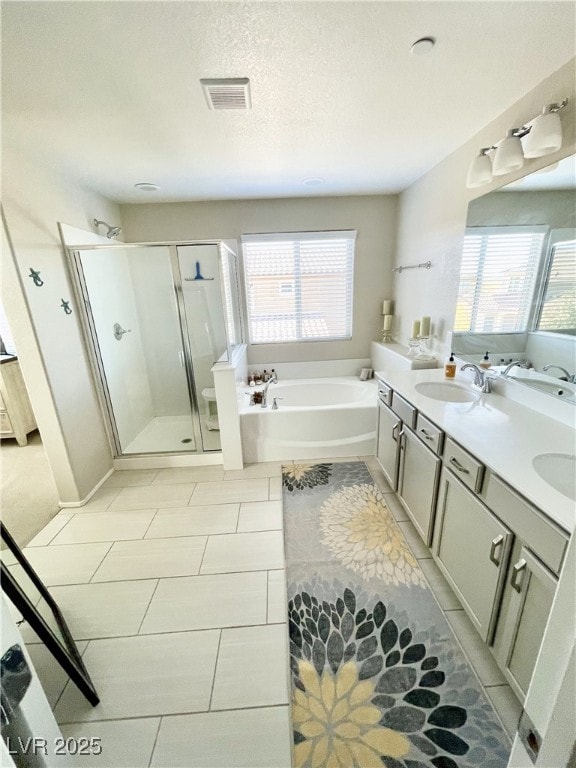 bathroom featuring vanity, tile patterned floors, plus walk in shower, and a textured ceiling