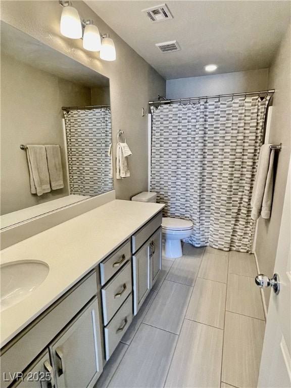 bathroom with a shower with curtain, vanity, and toilet