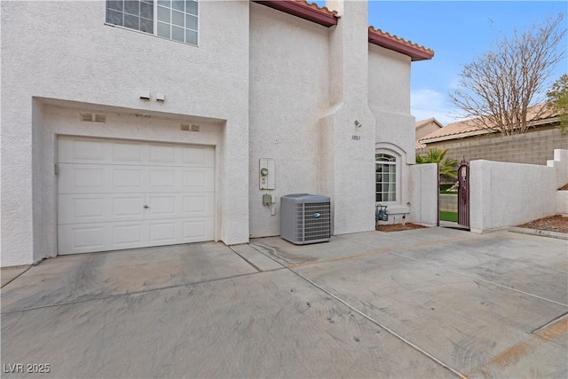 exterior space with a garage and central AC