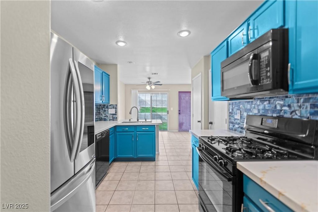 kitchen featuring black appliances, sink, light tile patterned floors, kitchen peninsula, and blue cabinetry